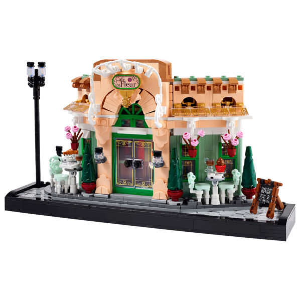 Miniature café en briques LEGO, décoration élégante avec terrasse, parasols roses, et éclairages, parfait pour une ambiance parisienne ou de quartier chic, idéal pour collectionneurs et amateurs de LEGO.