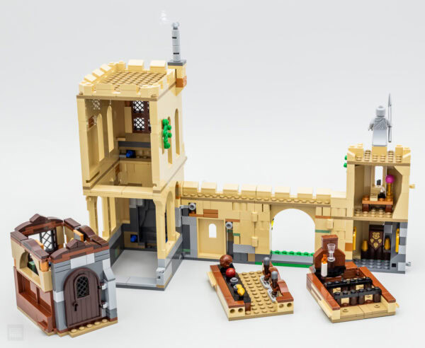 Un château médiéval construit avec des briques LEGO, comprenant une tour, une porte, un pont et des détails de décoration, parfait pour une collection LEGO ou une décoration créative.