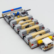 Légende alternative : Modèle détaillé de voiture en LEGO avec éléments jaune, gris, beige et noir, présenté sur fond blanc.