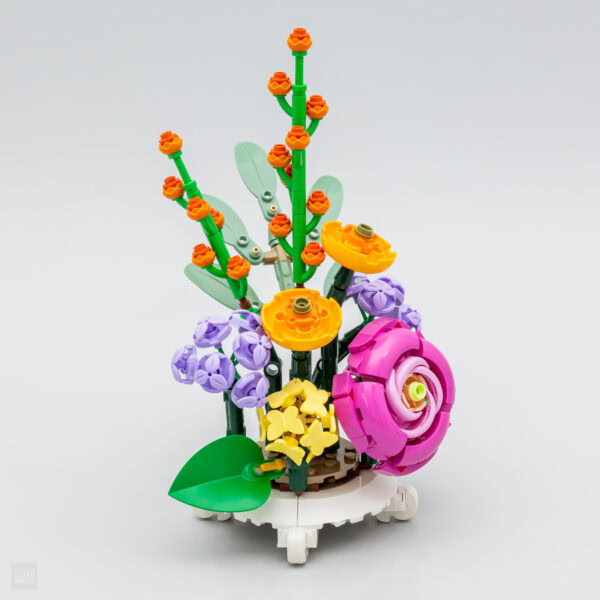 Colorful LEGO flower arrangement with pink rose, yellow, purple, and orange blossoms, green leaves, and intricate details, perfect for creative building and decorative displays.