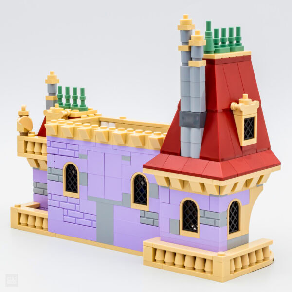 Fabrique de jouet LEGO en forme de château coloré, avec tours, fenêtres gothiques et toit rouge, idéal pour création de décor de rêve ou jeu imaginatif.