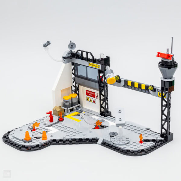 Accessoire LEGO de station de déneigement avec tuyaux, barrières, panneau de sécurité, et panneau de restriction pour un jeu d'imagination.