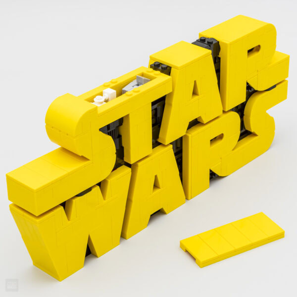 Vasque LEGO jaune en forme de "Stay Wavy" avec lettres 3D, création artistique et design innovant, idéal pour décoration intérieure ou collection de LEGO.