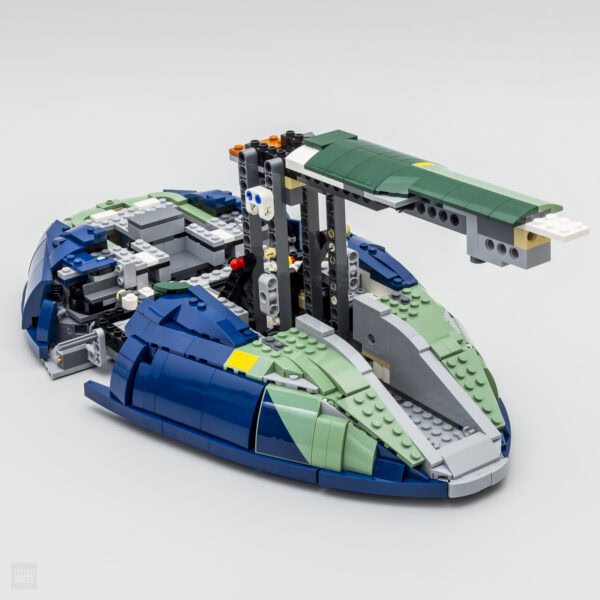 Véhicule de construction en briquettes LEGO avec design futuriste, coupes de bleu, vert et gris, comprenant une plateforme de levage et détails mécaniques.