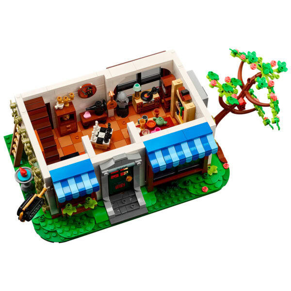 Véranda en briques LEGO avec mobilier, plantes et arbre, représentation d'une maison chaleureuse et conviviale, idéal pour la décoration et la collection LEGO.