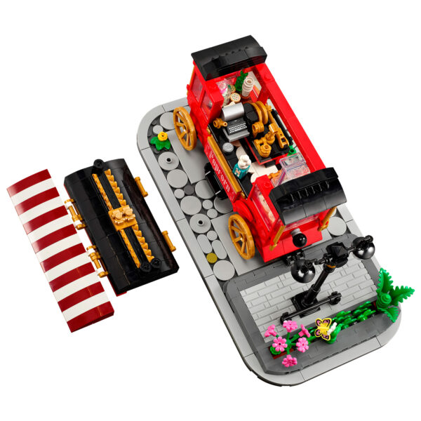 Ciel numérique, voiture ancienne LEGO rouge avec détails en or, fenêtres transparentes, petit lampadaire et rangée de fleurs colorées, parfait pour collectionneurs et amateurs de LEGO.